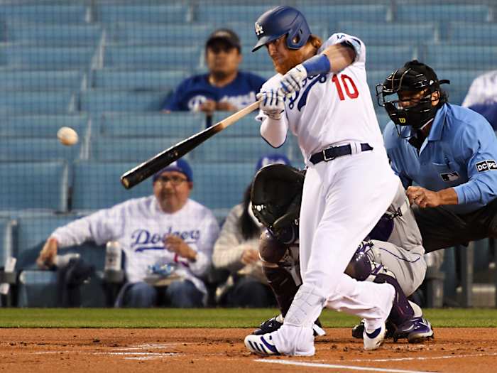 Apr 14, 2021; Los Angeles, California, USA;  Los Angeles Dodgers third baseman Justin Turner (10) singles in a run in the first inning of the game against the Colorado Rockies at Dodger Stadium.